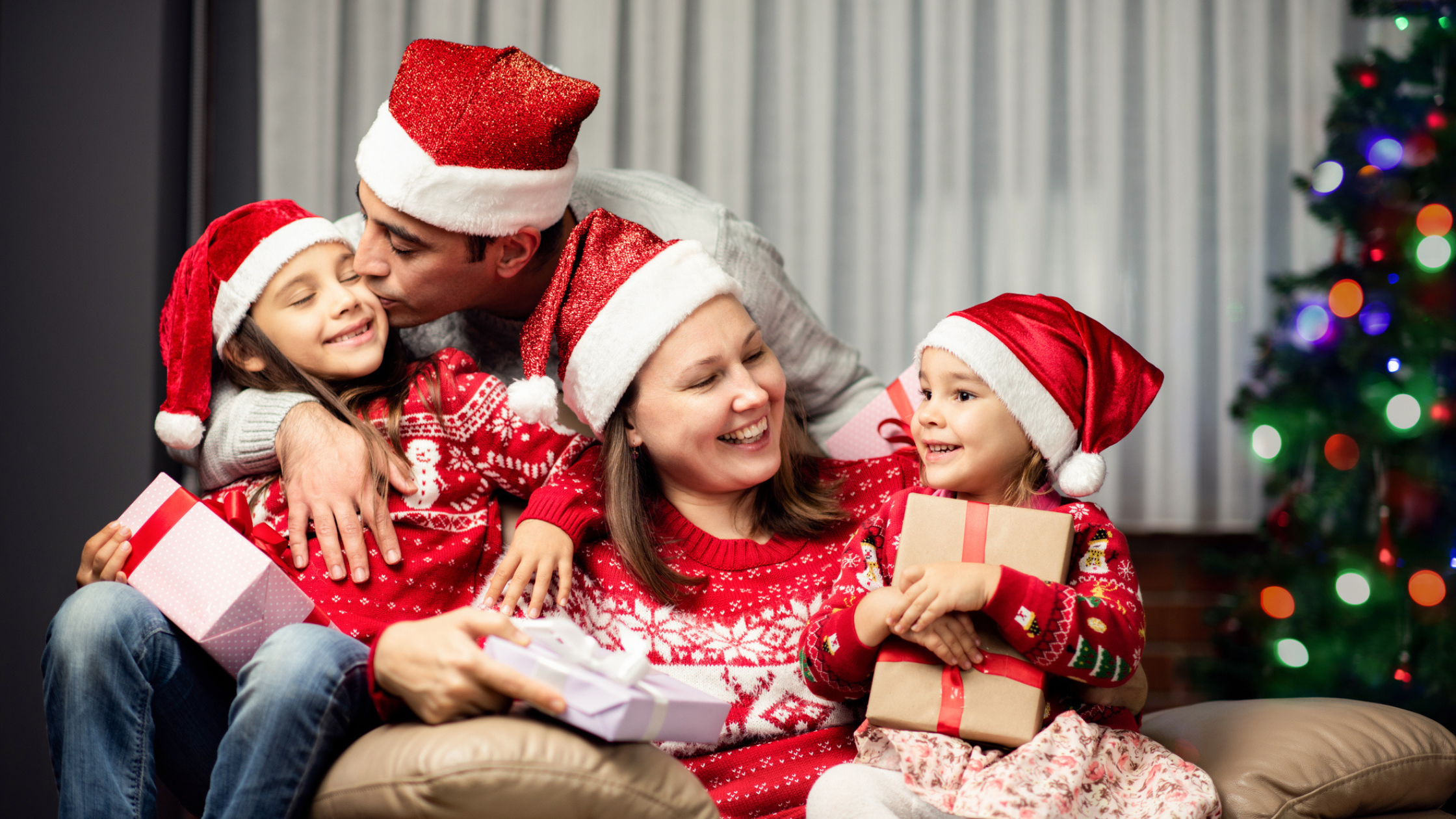 Family smiling holiday tree