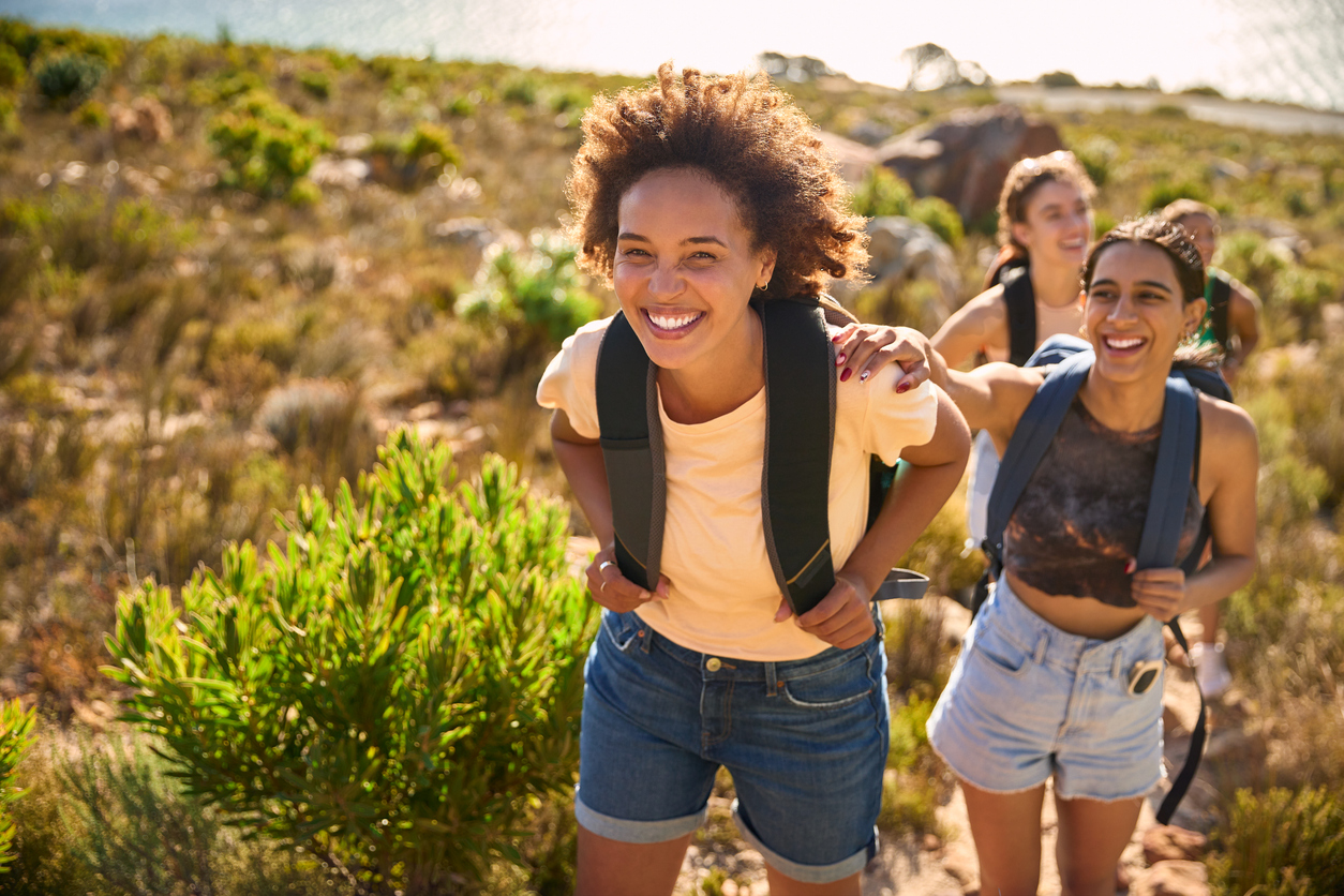 Young girls walking in nature with backpacks